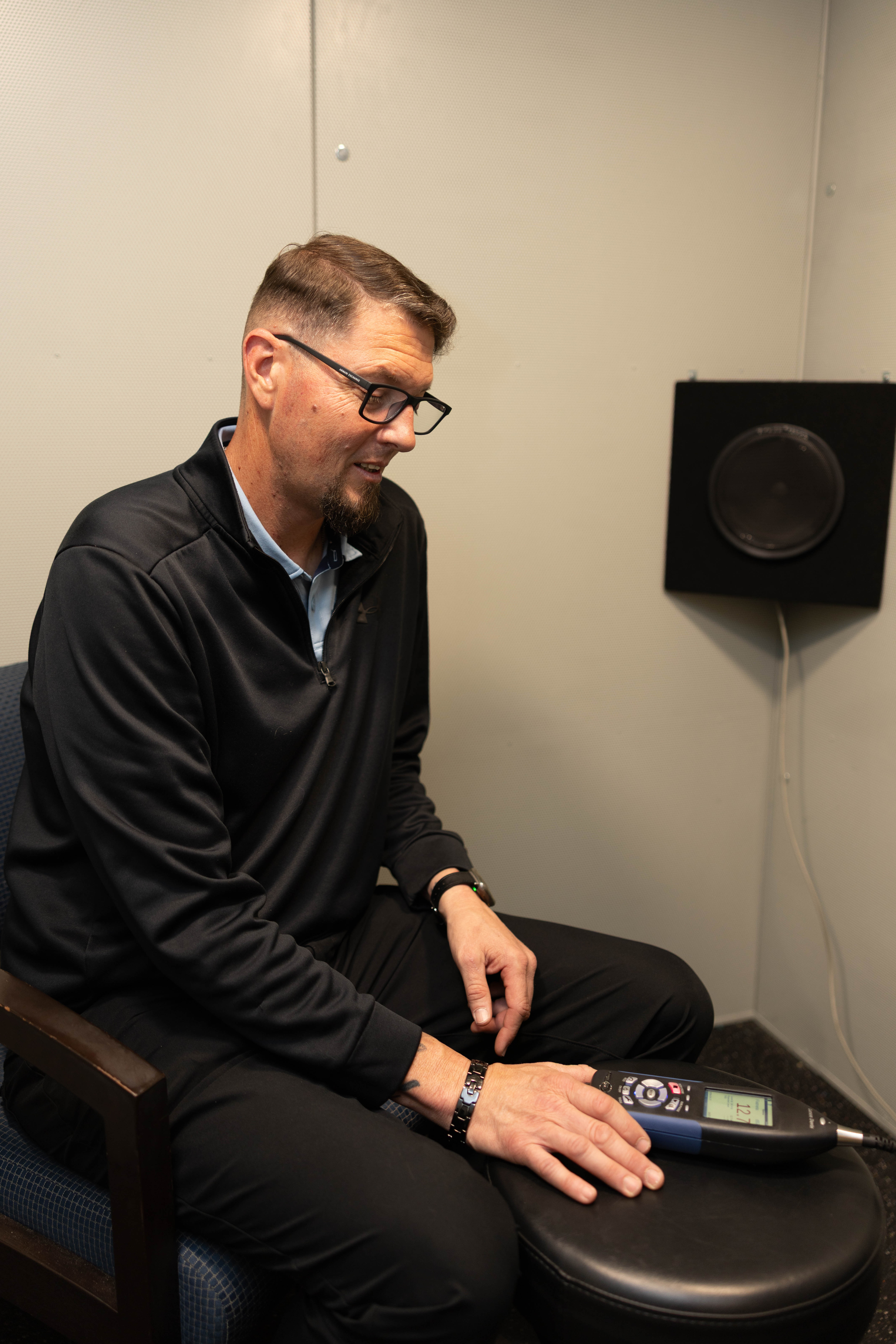 Sound booth interior with a sound-level meter during an on-site ambient noise verification